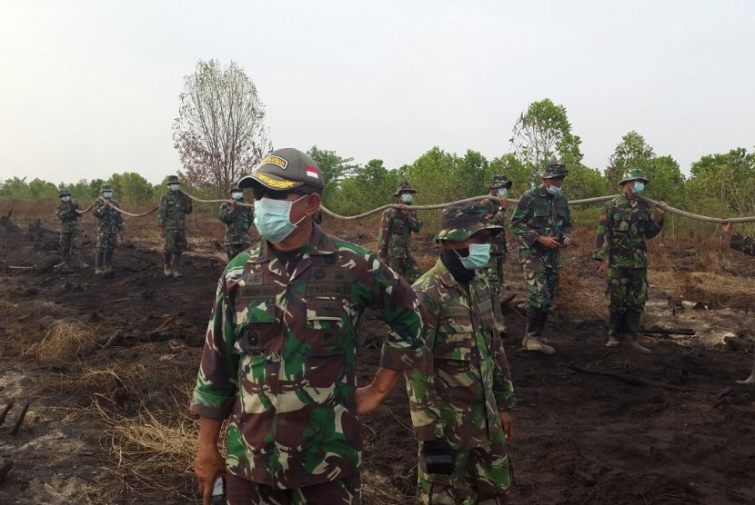 Pasukan TNI yang dikerahkan memadamkan api