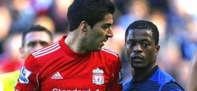Patrice Evra, bek Manchester United, terlibat adu mulut dengan Luis Suarez (kiri), striker Liverpool, di laga Liga Primer di Anfield, Liverpool.