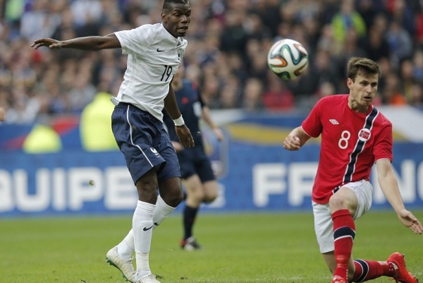 Paul Pogba (kiri) dihadang pemain Norwegia dalam laga persahabatan jelang piala dunia