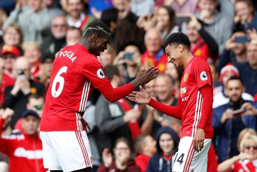 Paul Pogba (kiri) merayakan gol keempat Manchester United yang dicetaknya ke gawang Leicester City bersama Jesse Lingard.