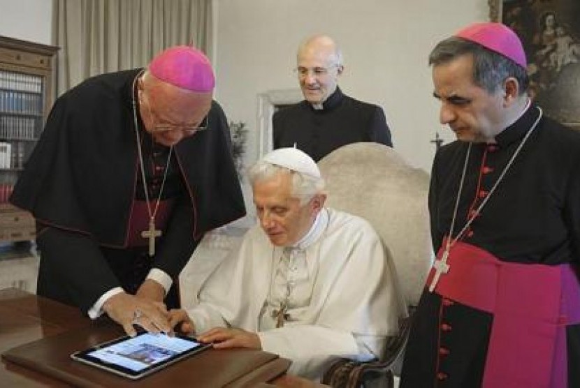 Paus Benediktus XVI (duduk) dipandu mengirimkan pesan Twitter dalam akun Vatikan pada 28 Juni 2011 lalu.