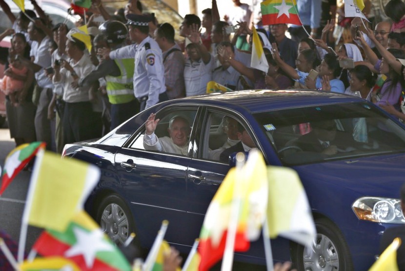 Paus Francis melambaikan tangan saat tiba di Yangon, Myanmar, Senin (27/11).