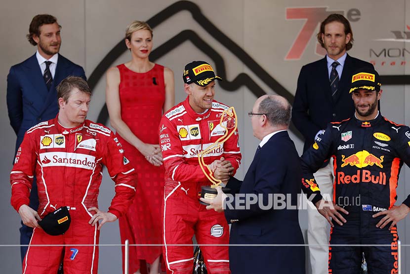 Pebalam Ferrari Sebastian Vettel menerima trofi dari Pangeran Albert usai memenangi balap F1 GP Monaco di Sirkuit Monte Carlo, Ahad (28/5). 