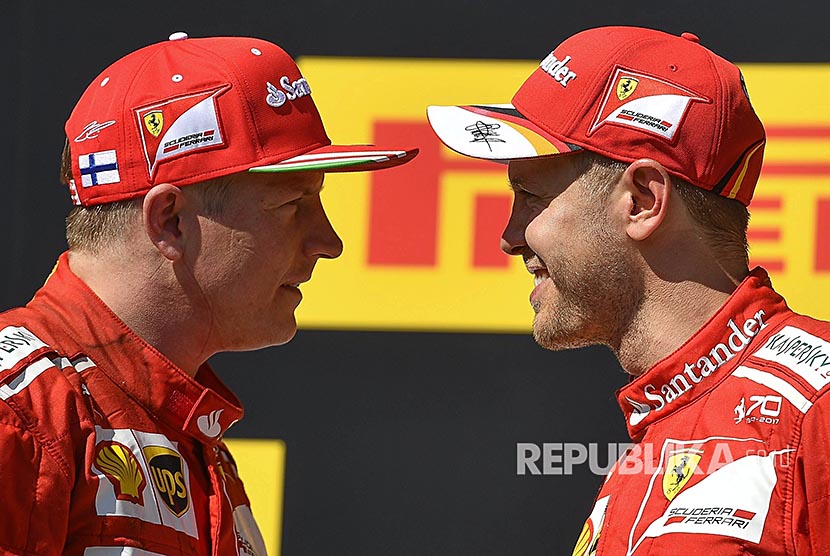 Pebalap Ferrari Sebastian Vettel (kanan) dan rekan se-timnya Finnish Kimi Raikkonen di podium Grandprix Hongaria di Sirkuit Hongaroring, Hongria, Ahad (30/7).
