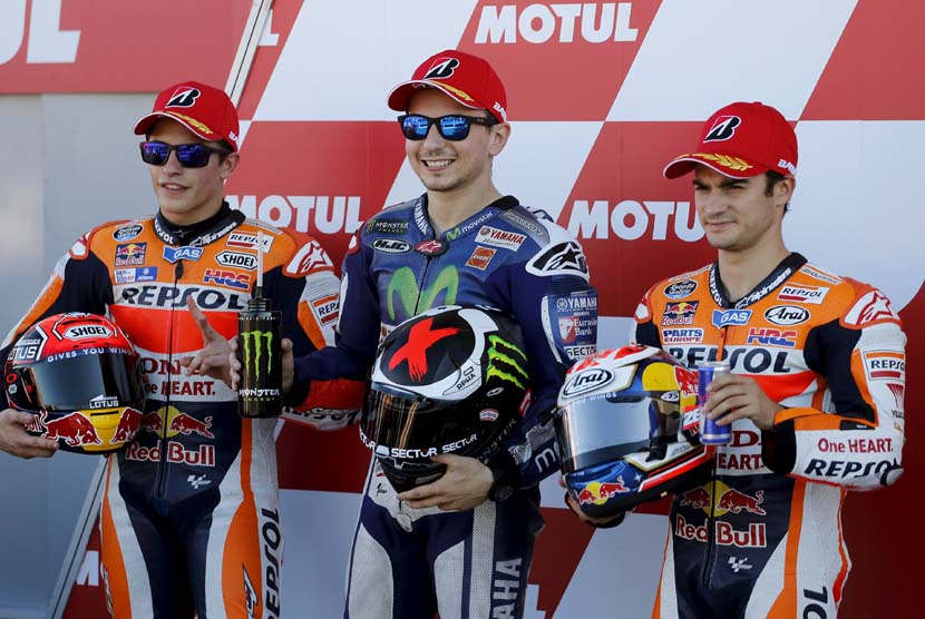 Pebalap Honda asal Spanyol, Marc Marquez (kiri), dan Dani Pedrosa berpose bersama kompatriot pebalap Yamaha, Jorger Lorenzo (tengah), usai balapan seri GP Valencia di Sirkuit Ricardo Tormo, Valencia, Spanyol, Ahad (8/11). 