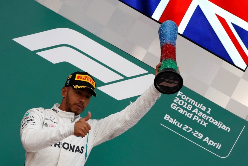 Pebalap Mercedes Lewis Hamilton mengangkat trofi setelah menjuarai Grand Prix F1 Azerbaijan di Sirkuit Baku, Azerbaijan.