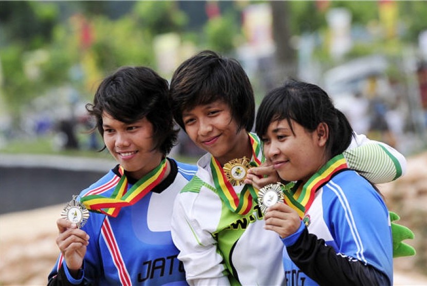 Pebalap sepeda Jawa Tengah, Suswanti (kiri) dan Rina Purnamasari (kanan), memperlihatkan medali pada final balap sepeda BMX PON XVIII di arena BMX, Siak, Riau. 