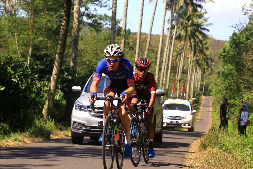 Pebalap sepeda Sapura Cycling Team Ewart Jesse (kiri) beradu cepat dengan pebalap sepeda KFC Cycling Team Selamat Juangga di tanjakan pada kejuaraan International Tour de Banyuwangi Ijen (ITDBI) di Banyuwangi, Jawa Timur, Sabtu (29/9).