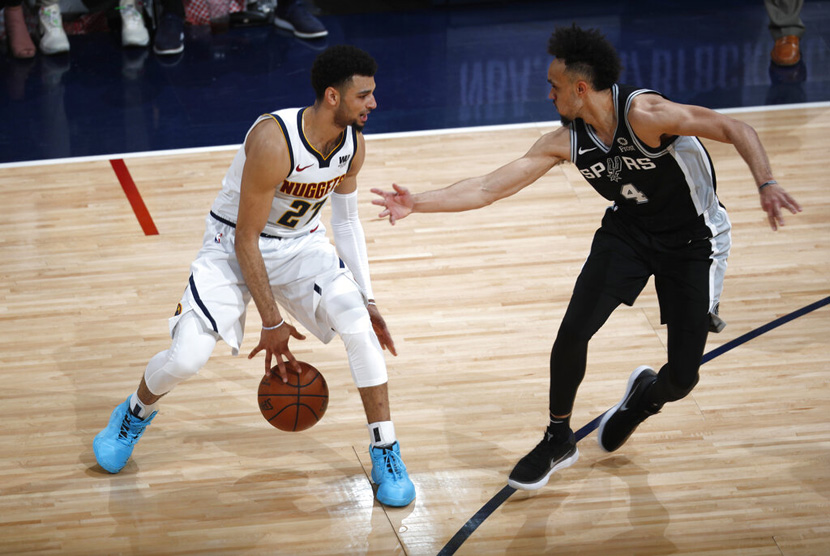 Pebasket Denver Nuggets Jamal Murray (kiri) mencoba melewati pebasket San Antonio Spurs Derrick White (kanan) di paruh kedua dari seri playoff bola basket NBA.