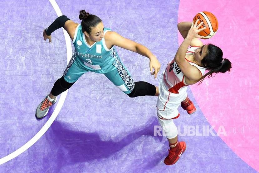 Pebasket Indonesia Christine Aldora dihadang oleh pemain Kazakhstan Zalina Kurazova saat melakukan Jump Shoot di babak penyisihan Basket Putri Grup X Asian Games ke 18 di Hall Basket Senayan, Jakarta, Ahad (19/8). 
