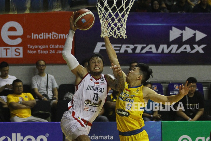 Pebasket Indonesia Patriots Brandon Van Dom Jawato (kiri) melakukan lay up dihadang pebasket Satya Wacana Salatiga Antoni Erga (kanan) saat pertandingan seri keenam Indonesian Basketball League (IBL) Pertamax 2020 di DBL Arena, Surabaya, Jawa Timur, Jumat (6/3/2020). 