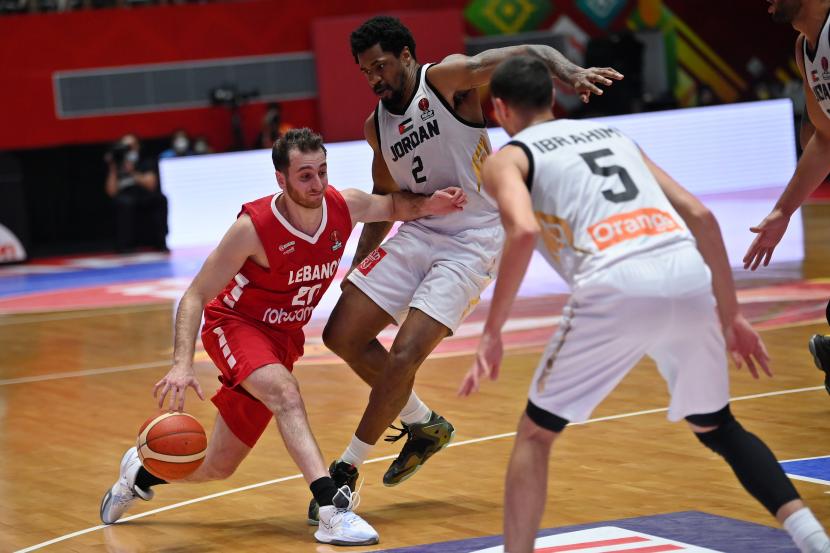 Pebasket Lebanon Wael Arakji (kiri) berusaha menembus hadangan pebasket Yordania Dar Tucker (tengah) dalam babak semi final FIBA Asia Cup 2022 di Istora Gelora Bung Karno, Senayan, Jakarta, Sabtu (23/7/2022). 