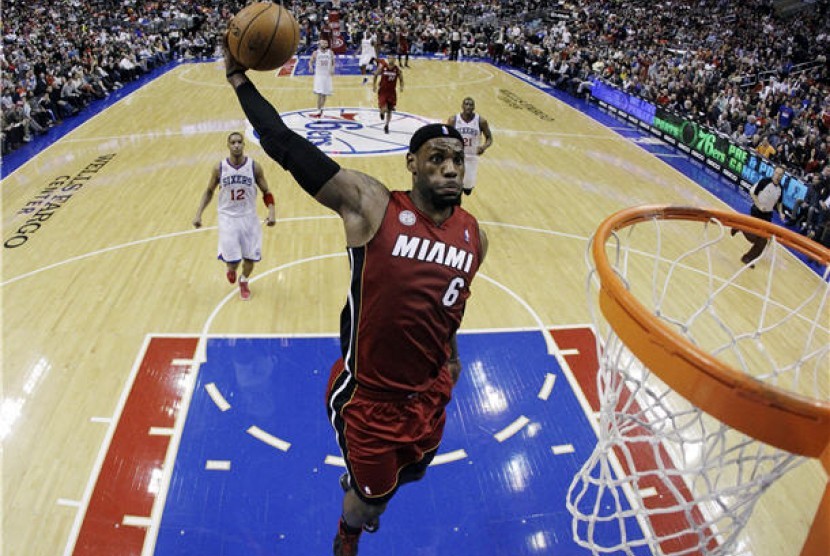 Pebasket Miami Heat, LeBron James, melakukan aksi dunk saat menghadapi Philadelphia 76ers di laga NBA di Philadelphia pada Rabu (13/3). 