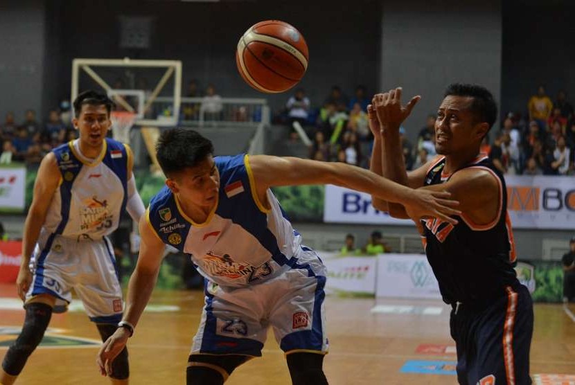 Pebasket Pelita Jaya Amin Prihantono (kanan) berebut bola dengan pebasket Satria Muda Pertamina Avan Seputra (tengah) saat gelaran final Indonesia Basket League di Britama Arena, Jakarta, Ahad (7/5) malam. 