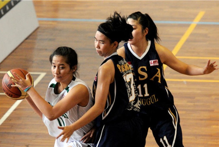 Pebasket putri Universitas Esa Unggul (biru) berusaha menghadang pergerakan pemain lawan dalam laga lanjutan Liga Mahasiswa (LIMA).