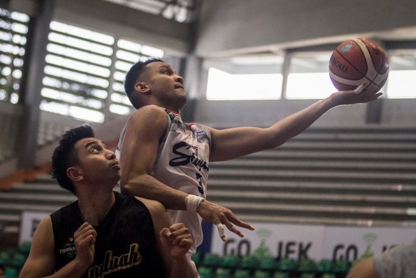 Pebasket Stapac Jakarta, Kaleb Ramot Gemilang (kanan) berusaha mencetak angka dengan dihadang pebasket Hangtuah, Steven Carsera (kiri) pada Turnamen Pramusim Indonesian Basketball League (IBL) di Gor Sritex Arena, Solo, Jawa Tengah, Rabu (17/10/2018). Pada pertandingan tersebut Stapac Jakarta menang dengan skor 68-59.