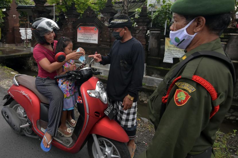 Pecalang dan petugas Linmas menegur pengendara sepeda motor yang tidak menerapkan protokol kesehatan dalam Pemberlakuan Pembatasan Kegiatan Masyarakat (PPKM) tingkat desa/kelurahan di Denpasar, Bali (ilustrasi)