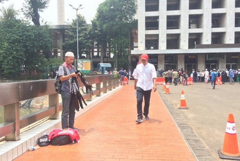 Pedagang atribut bertuliskan kalimat tauhid menawarkan dagangannya di kawasan Masjid Istiqlal, Jumat (26/10)