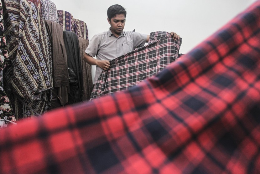 Pedagang bahan tekstil menata kain dagangannya di Sentra Tekstil, Kawasan Cipadu, Tangerang Selatan, Banten, Rabu (25/7). Pemerintah telah menyiapkan peta jalan Making Indonesia 4.0 menyambut revolusi industri.