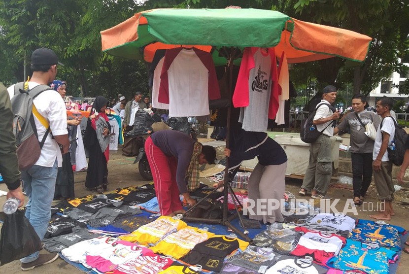 Pedagang baju dengan ikon Jakarta berjualan di halaman Masjid Istiqlal dalam reuni 212 yang berlangsung Ahad (2/12). 