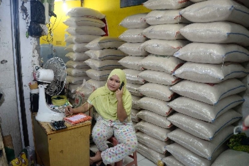   Pedagang berada di toko agen beras di Jakarta Selatan, Ahad (22/3).