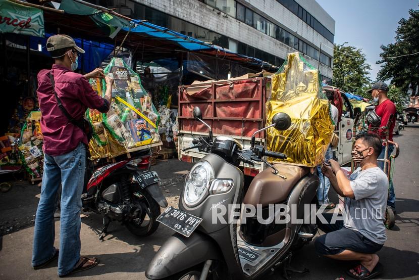 Pedagang bersiap mengirimkan parsel ke pembeli di kawasan Cikini, Jakarta, Selasa (27/4/2021). Pedagang parsel musiman di kawasan tersebut menjual harga parcel kisaran Rp150 ribu hingga Rp3 juta tergantung dari model parcel yang di minta pembeli.