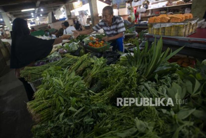 Pedagang dan pembeli bertransaksi sayur-sayuran di Pasar Minggu, Jakarta, Kamis (10/6/2021). 