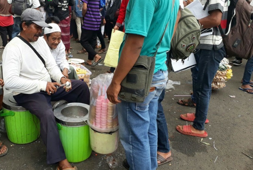 Pedagang es krim yang memberikan dagangannya secara gratis kepada peserta aksi 313, di sekitar Masjid Istiqlal, Jakarta, Jumat 31/3).