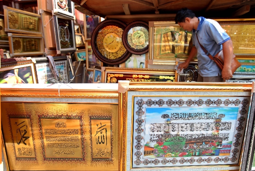 Pedagang hiasan Kaligrafi menata barang dagangannya di Pasar Baru, Jakarta, Rabu (22/6). 