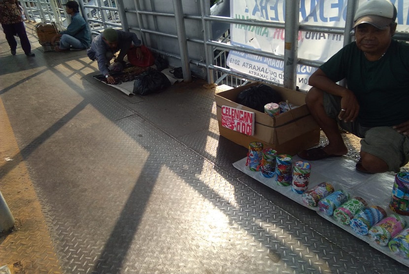 Pedagang kaki lima menjajakan barang dagangannya di lantai JPO Jatinegara, Jakarta Timur