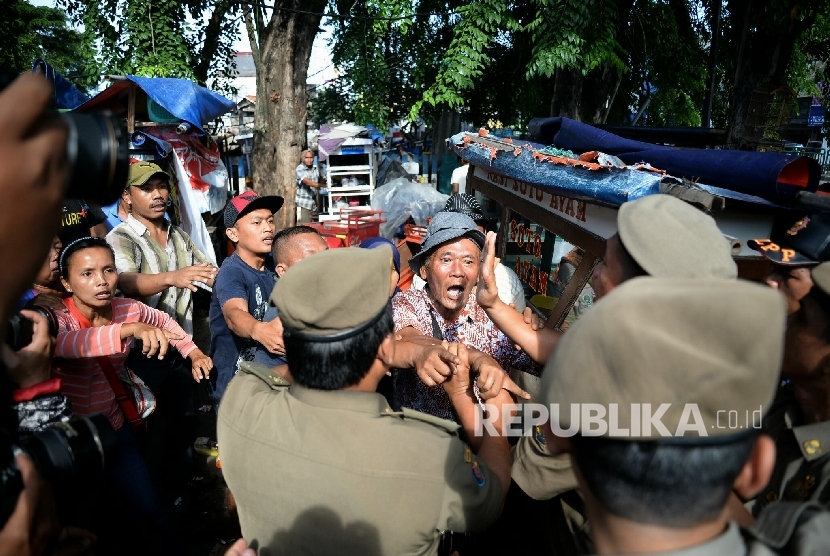 Pedagang kaki lima (PKL) berteriak menolak gerobaknya dibawa oleh petugas Pol PP di kawasan Kota, Jakarta, Selasa (25/10).  (Republika/Prayogi)