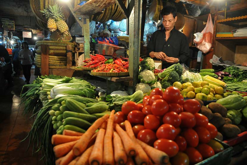 Pedagang komoditas bahan makanan melayani pembeli di pasar tradisional. ilustrasi