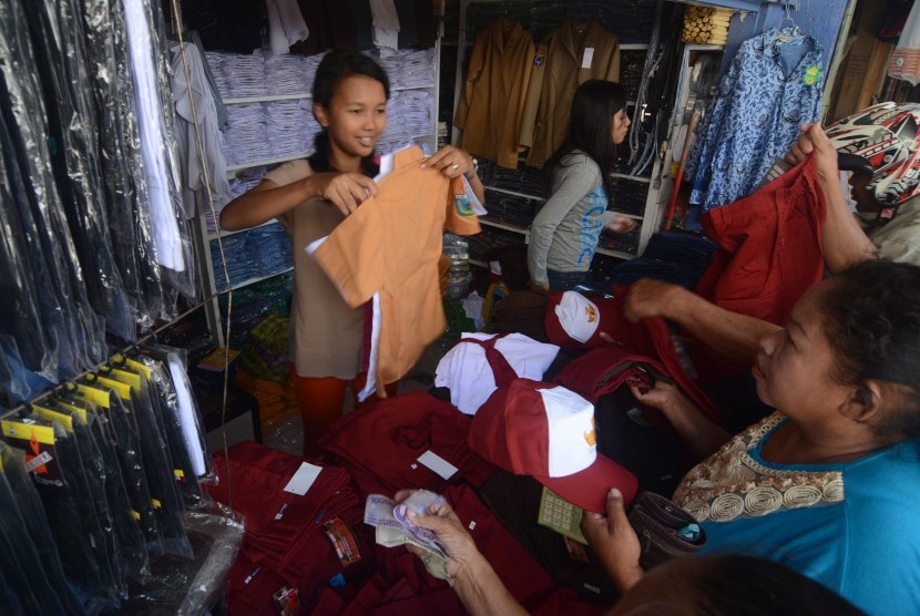 Pedagang melayani orang tua siswa yang membeli perlengkapan seragam sekolah di salah satu toko seragam sekolah di Palu, Sulawesi Tengah, Rabu (2/7).