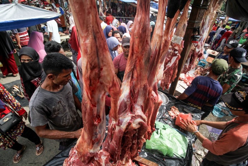 Pedagang melayani pembeli daging sapi pada perayaan tradisi Meugang Akbar Idul fitri 1440 di Lhokseumawe, Aceh, Selasa (4/6/2019). 