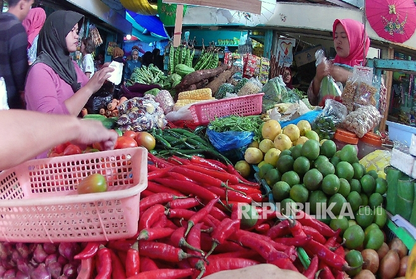 Pedagang melayani pembeli di pasar tradisional.