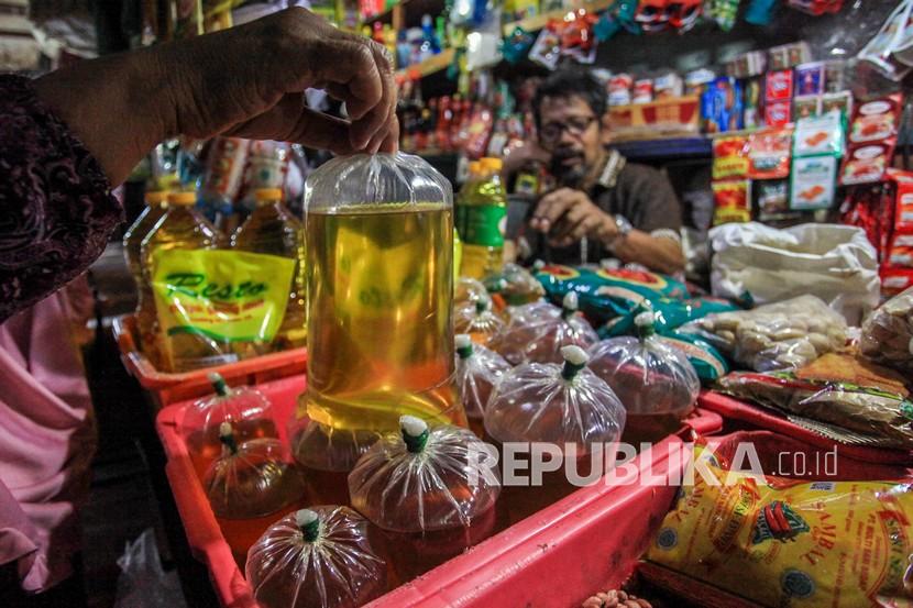 Pedagang melayani pembeli minyak goreng curah di pasar. Minyak goreng di pasar tradisional di Solo, Jawa Tengah, masih di atas HET