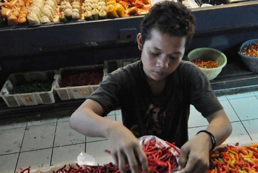 Pedagang melayani warga membeli bahan bumbu dapur di Pasar Kramat Jati, Jakarta, Ahad (22/12). Menjelang hari Natal 2013 dan Tahun Baru 2014, komoditi-komoditi kebutuhan pokok mayarakat di sejumlah pasar tradisional mengalami kenaikan harga antara sepuluh 