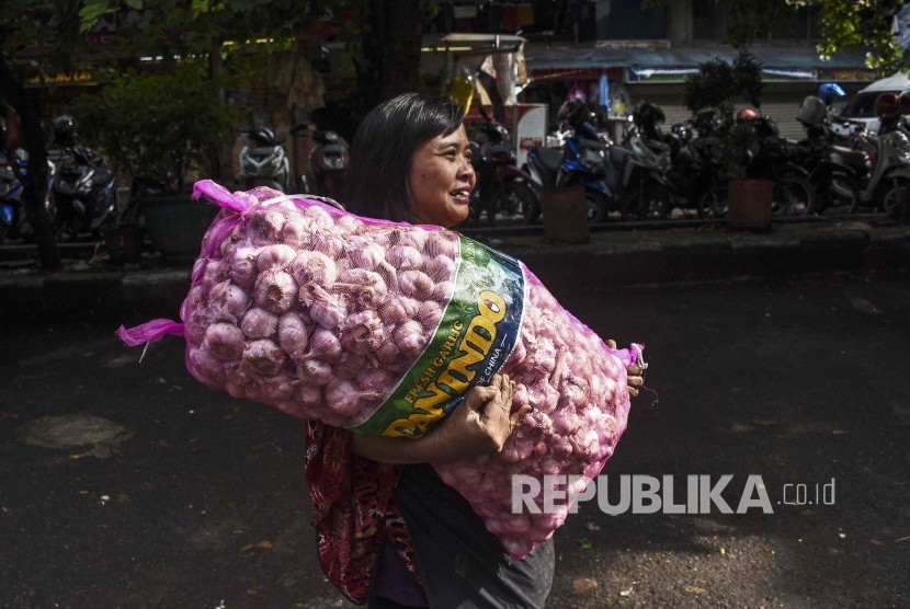 Pedagang membawa karung yang berisi bawang putih saat operasi pasar di Pasar Kosambi, Kota Bandung, Jumat (10/5).