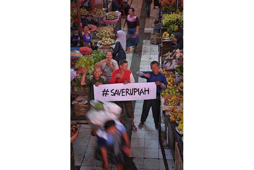  Pedagang membawa spanduk bertuliskan Save Rupiah di Pasar Gede, Solo, Jawa Tengah, Kamis (12/3).  (Antara/Yusuf Nugroho)