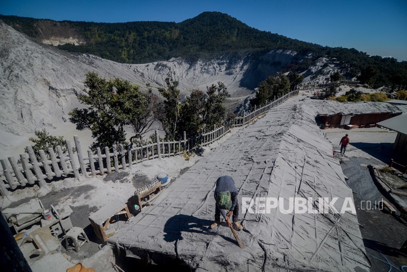 Pedagang membersihkan atap kiosnya dari debu vulkanik pascaerupsi Gunung Tangkuban Perahu  (ilustrasi)