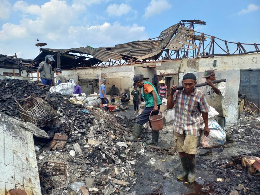 Pedagang membersihkan sisa-sisa kebakaran di Pasar Ciawi, Kecamatan Ciawi, Kabupaten Tasikmalaya, Senin (19/12/2022). 
