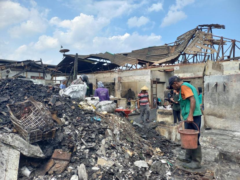 Pedagang membersihkan sisa puing pascakebakaran di Pasar Ciawi, Kecamatan Ciawi, Kabupaten Tasikmalaya, Senin (19/12/2022). Sedikitnya, sebanyak 158 kios hangus terbakar akibat kebakaran yang terjadi pada Ahad (18/12/2022) sore. 