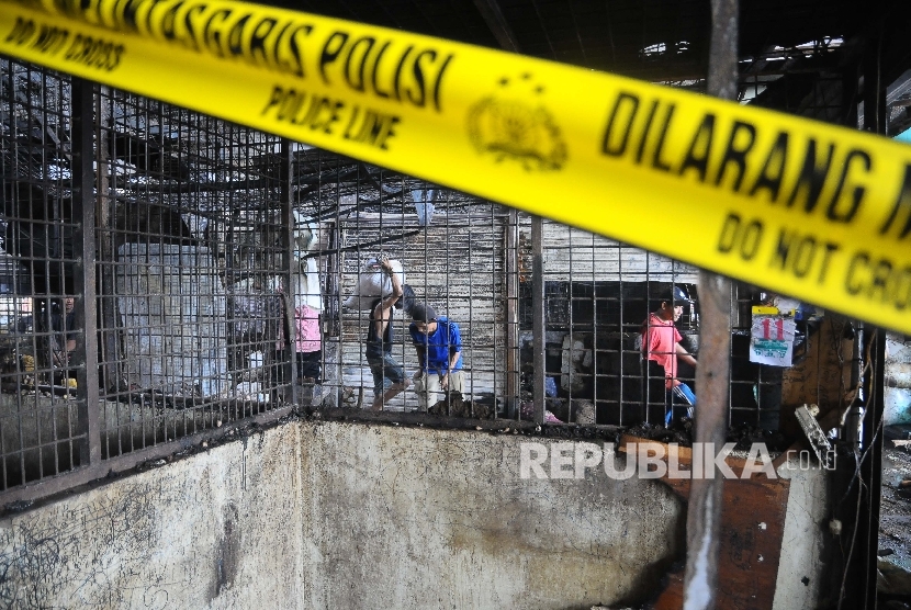 Pedagang membersihkan sisa-sisa kios yang terbakar di Pasar Induk Kramatjati, Jakarta, Senin (12/6).