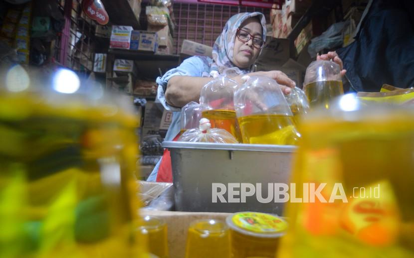 Pedagang membungkus minyak goreng curah di Pasar Raya Padang, Sumatera Barat, Senin (31/1/2022). Menteri Perdagangan Muhammad Lutfi mengatakan, harga minyak goreng Rp 8.000 per liter di Malaysia itu karena ada subsidi.