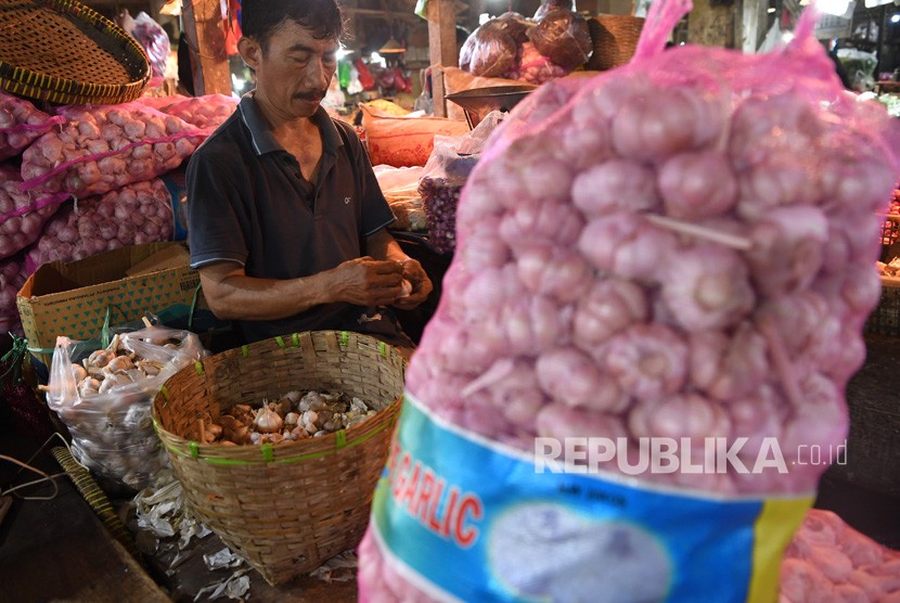 Pedagang memilah bawang putih yang dijual di Pasar Keputran, Surabaya, Jawa Timur, Jumat (14/6/2019).