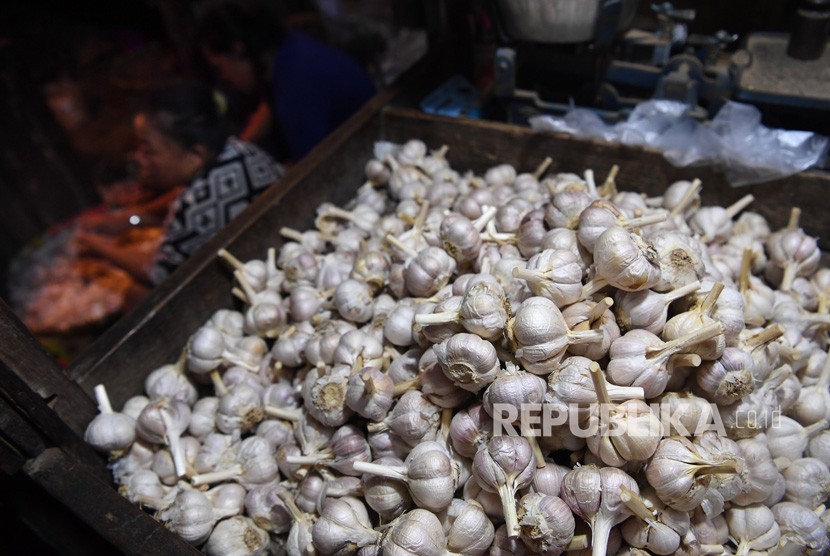 Pedagang memilah bawang putih yang dijual di Pasar Keputran, Surabaya, Jawa Timur, Jumat (14/6/2019). 