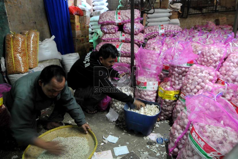  Pedagang memilah dan menimbang bawang putih di Pasar Induk Kramat Jati, Selasa (26/3).  (Republika/Wihdan Hidayat)