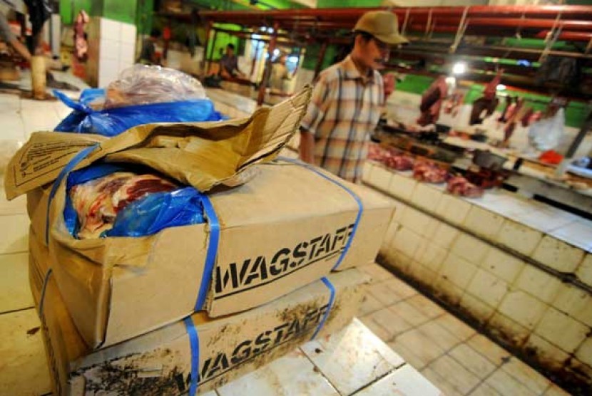 Pedagang memilah kotakan kardus berisi daging sapi impor Bulog di Pasar Jatinegara, Jakarta, Rabu (17/7).