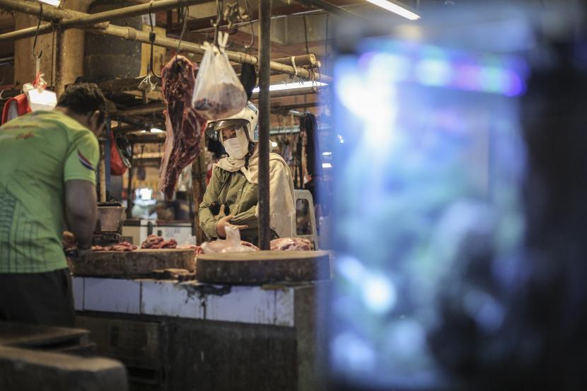 Pedagang memotong daging pesanan pembeli di Pasar Palmerah, Jakarta, Senin (9/8/2021). Sertifikat vaksinasi COVID-19 resmi diberlakukan sebagai syarat untuk beraktivitas di tempat-tempat publik di Jakarta, salah satunya pasar tradisional.