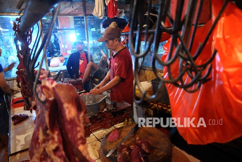 Pedagang memotong daging sapi di Pasar Grogol, Jakarta Barat, Selasa (27/12).